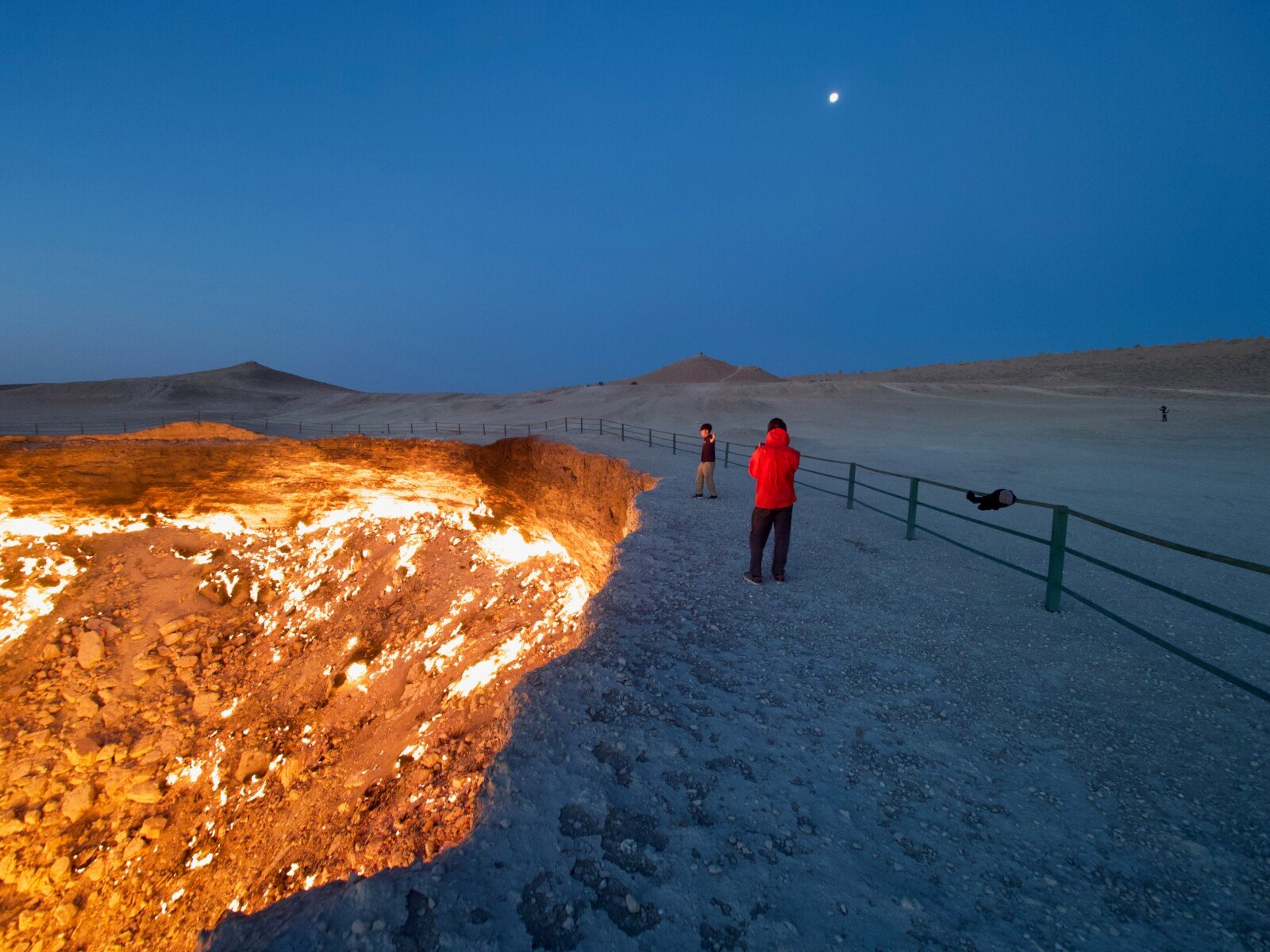 People standing on the edge of the Gates of Hell in Turkmenistan