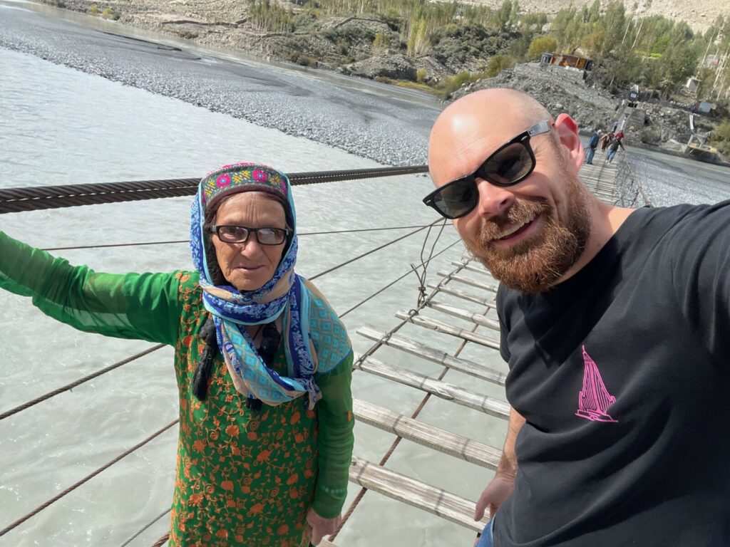 Visitor meeting a local person on the Hussaini Bridge in Passu, Pakistan