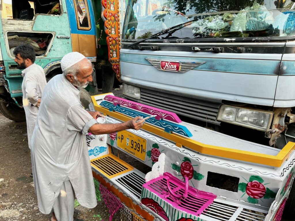 Pakistani man painting front of truck