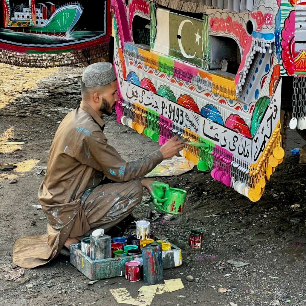 Pakistani man painting front of truck